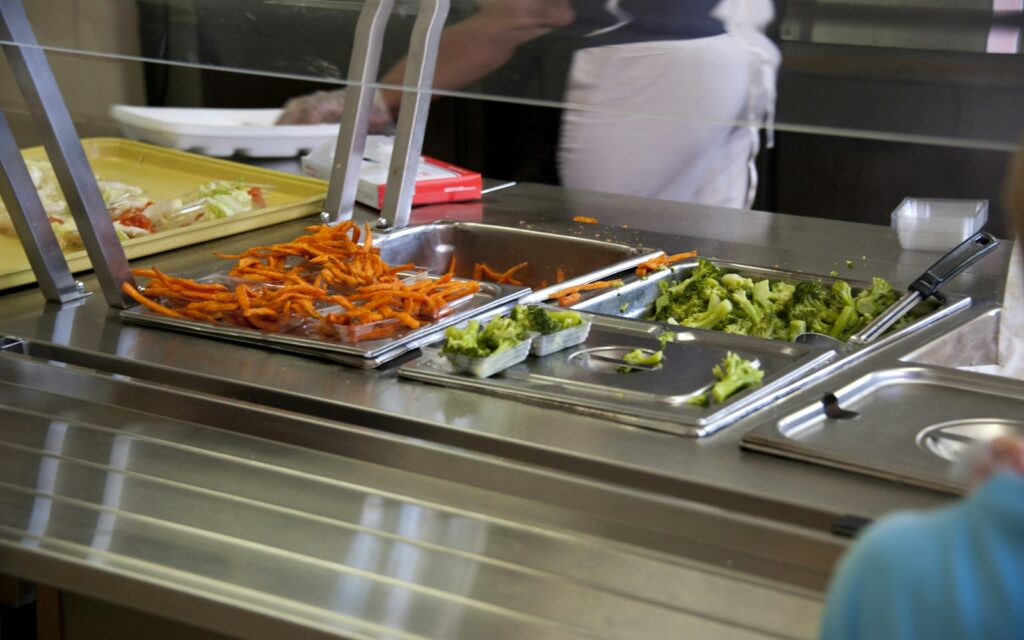 Línea de autoservicio de un comedor colectivo con bandejas de comida
