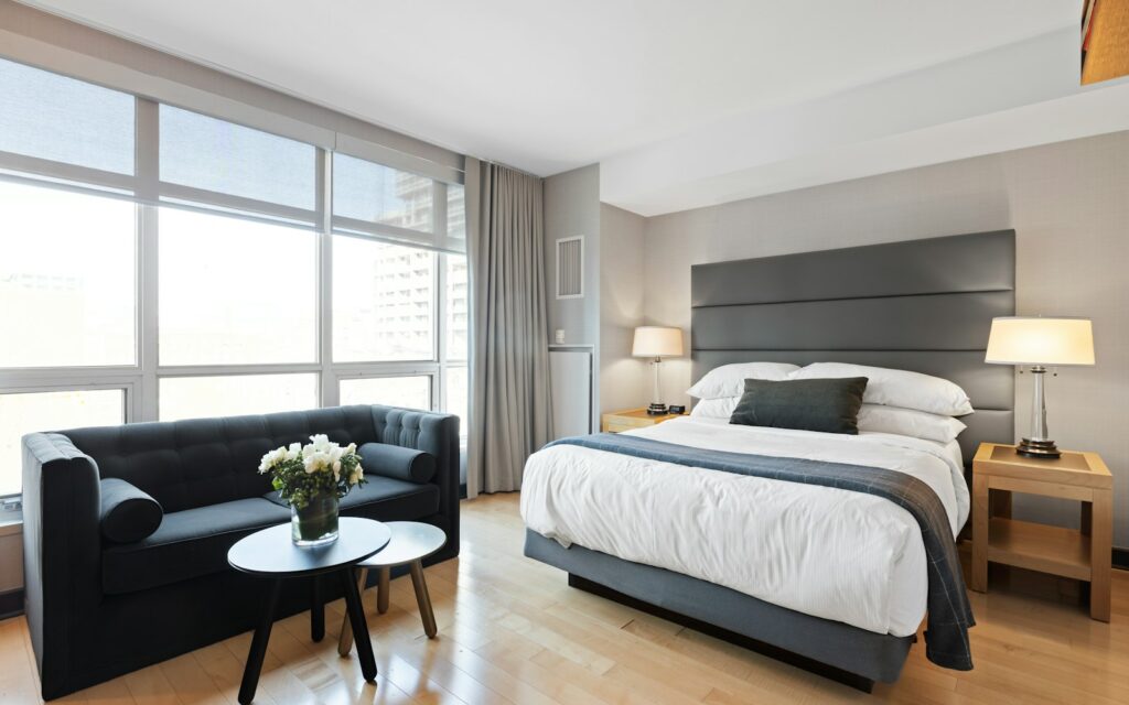 Habitación de hotel luminosa con cama doble y zona de estar